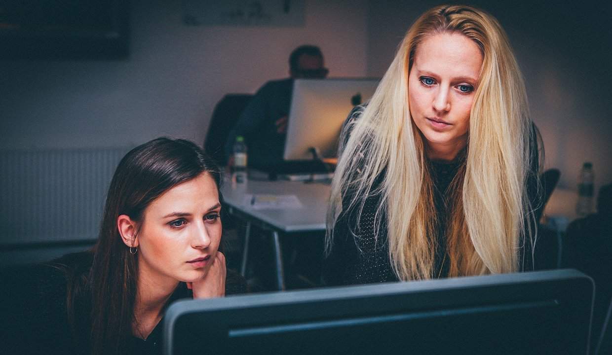Female web developers looking at computer